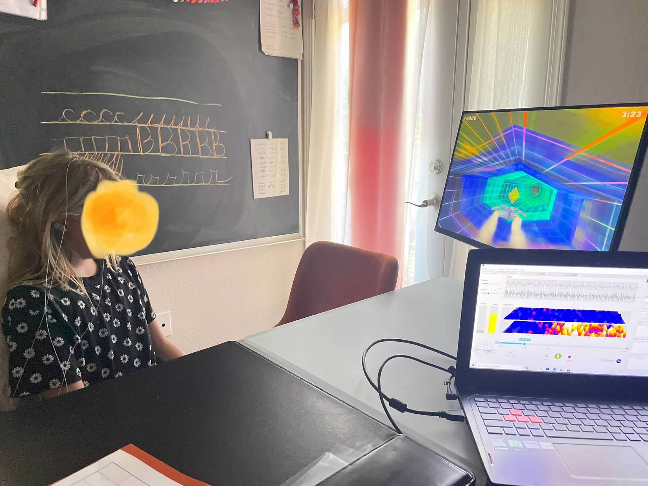 Child in neurofeedback session watching colorful brain training game
