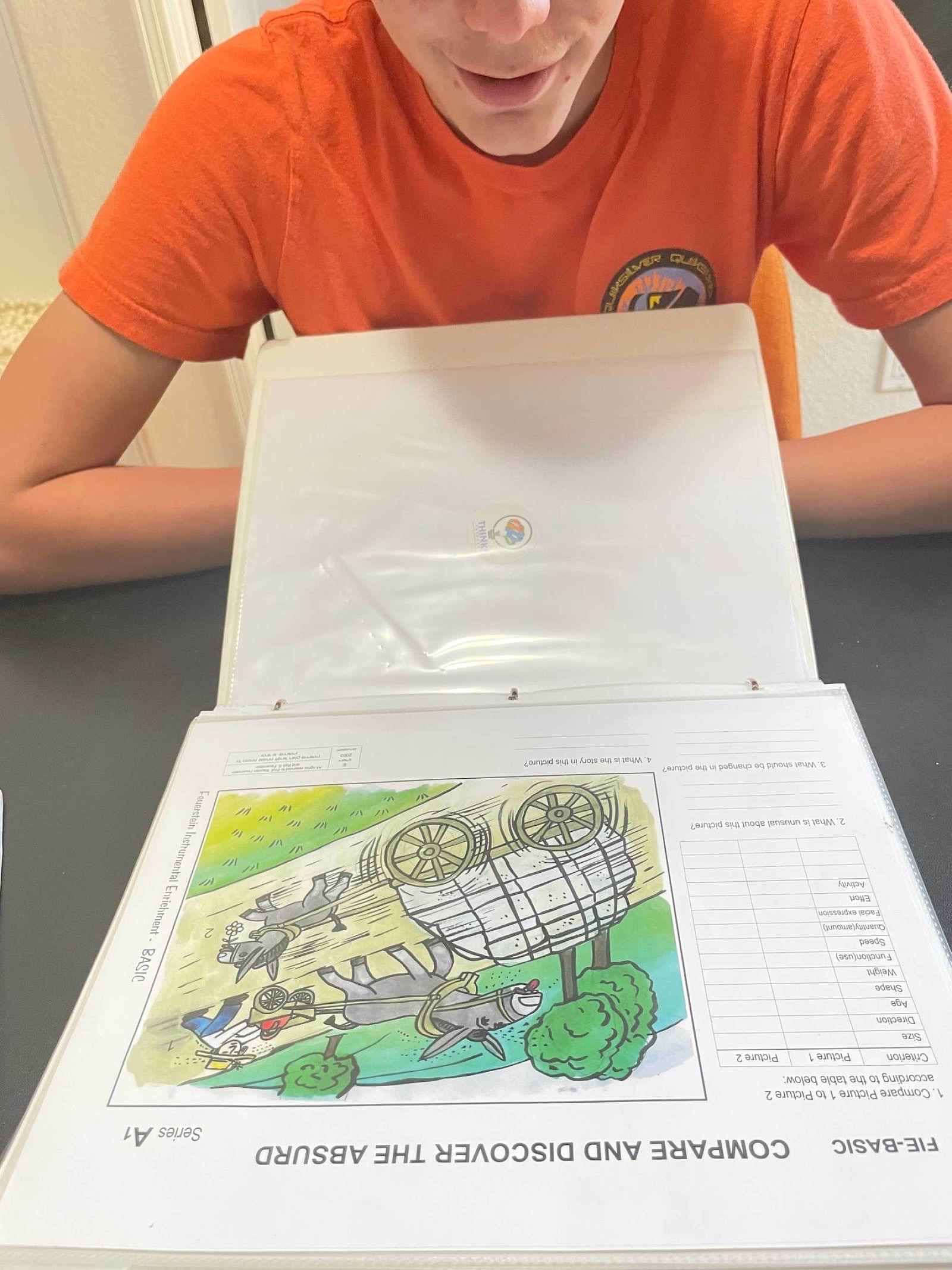 Student with FIE Compare and Discover the Absurd binder