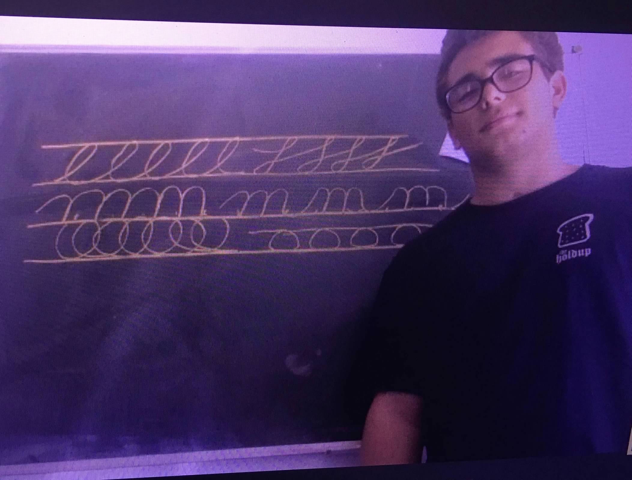 Teen at chalkboard doing cursive practice