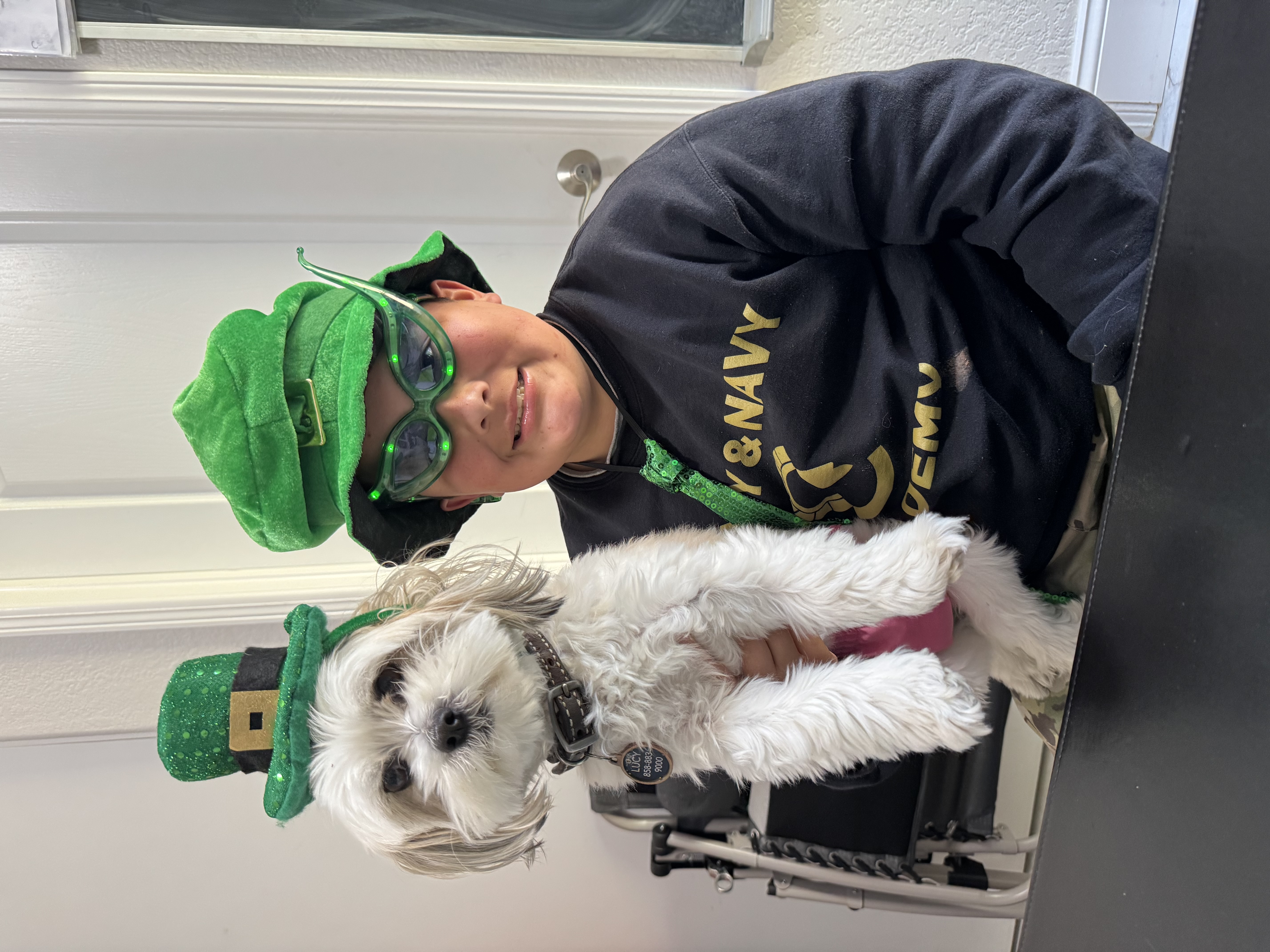 Student with therapy dog Lucy in St. Patrick's Day hats